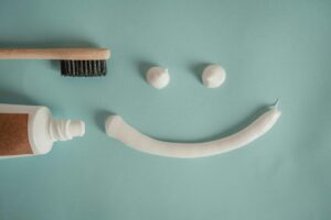 https://www.pexels.com/photo/toothbrush-a-a-tube-of-toothpaste-and-a-smile-painted-with-toothpaste-15694640/ Toothpaste and toothbrush in the shape of a smiley face